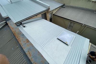 Corroded sheeting alongside the new work
